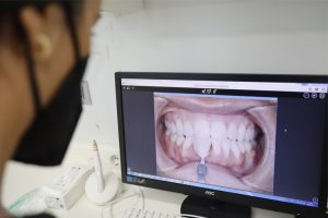 Dentista en Oviedo examinando la dentadura de un paciente tras una ortodoncia